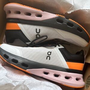 On Running Sneakers with White, Orange, and Black Accents